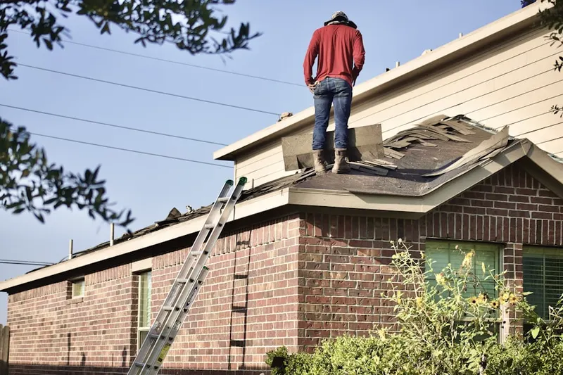Professional roofer working on a residential roof in Outer Comstock